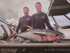 Dos hombres sosteniendo un pez en la parte trasera de un barco en Paradise HQ Pukenui, en Pukenui 12 fotos más