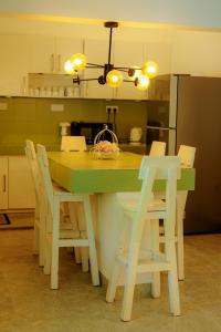 a kitchen with a table with chairs and a kitchen with a refrigerator at Istana Villa Mirissa in Mirissa +26 photos