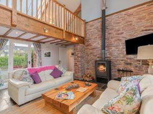 a living room with two couches and a fireplace at The Old Cowshed in Saint Ishmaels