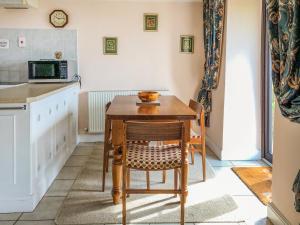a kitchen with a small wooden table and chairs at Hideaway in Brompton Ralph