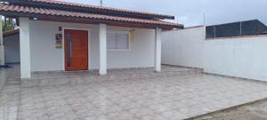 ein kleines Haus mit einer roten Tür auf einer Terrasse in der Unterkunft Casa na praia mongagua próximo da plataforma in Mongaguá