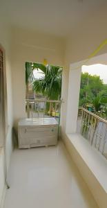 a room with a balcony with a large window at ISKCON Mayapur Apartments - Daily & Monthly Rentals- PRIME LOCATION - SERVICED Apartment, 5 MIN to MAIN ISKCON TEMPLE in mayapur