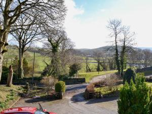 a driveway with a car parked in a garden at Pipit Cottage in Burnsall +8 photos