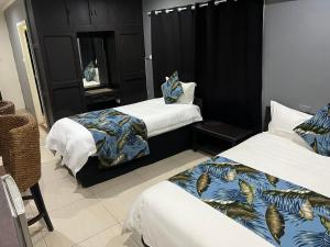 a hotel room with two beds and a mirror at Matasawa Resort - Wailoaloa, Nadi in Nadi +5 photos