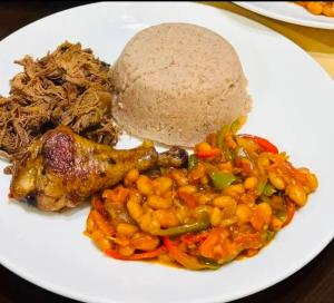 a white plate of food with beans and rice at Shado's residence self catering cotages in Serowe