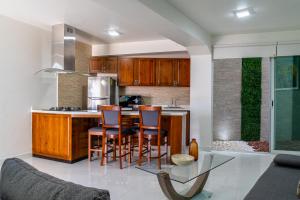 a kitchen with wooden cabinets and a glass table at Galerias Oaxaca Suites in Oaxaca City