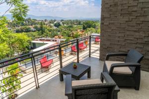 a balcony with chairs and a table on a building at Galerias Oaxaca Suites in Oaxaca City