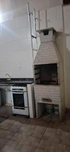 eine Küche mit einem Pizzaofen in der Ecke in der Unterkunft Casa na praia mongagua próximo da plataforma in Mongaguá