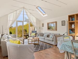 un salon avec des meubles blancs et une grande fenêtre dans l'établissement Carew Cottage, à Manorbier 24 autres photos