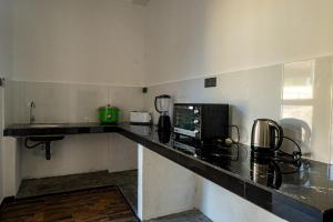 a kitchen with a counter top with a microwave at Bailey Beach Villa in Ahangama