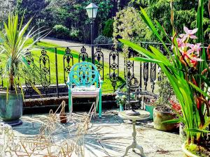 ein blauer Stuhl neben einem Zaun mit Pflanzen in der Unterkunft Kipling Cottage in Burwash + 27 Fotos