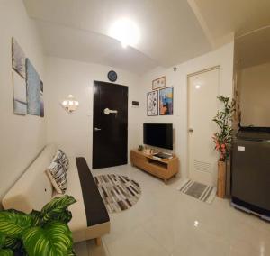 a living room with a couch and a television at 2 Bedroom Condo UDH by ZX Homes Banilad in Mandaue City