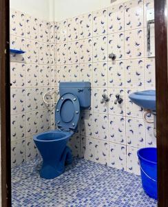 a bathroom with a blue toilet and a sink at Siva Inn in Guruvāyūr