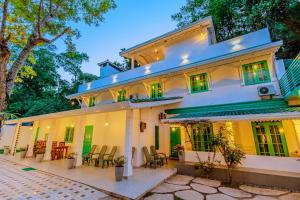 an exterior view of a white house with chairs and tables at Istana Villa Mirissa in Mirissa