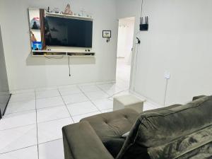 a living room with a couch and a flat screen tv at Quarto privativo para cop 30 in Ananindeua