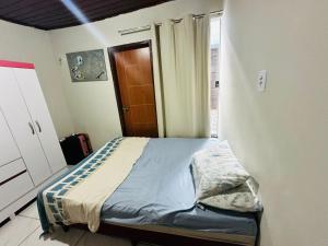 a small bed in a room with a window at Quarto privativo para cop 30 in Ananindeua