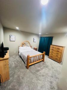 a bedroom with a bed and a dresser and a television at Rest and retreat river house in Grants Pass