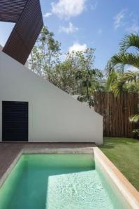 Tulum Villa 2 albercas 4hab hasta 16 personas 10min playa في تولوم: حمام سباحة في الفناء الخلفي للمنزل