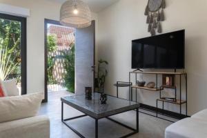 Tulum Villa 2 albercas 4hab hasta 16 personas 10min playa في تولوم: غرفة معيشة مع تلفزيون وطاولة قهوة