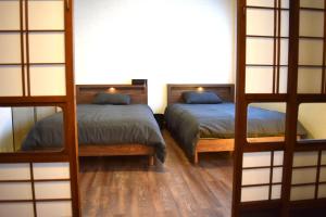 two bunk beds in a room with wooden floors at Hidasumika Daimon Cozyan in Takayama