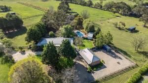 an aerial view of a house in a field with trees at Raygold Park Equestrian Accommodation plus Pool House in Moorooduc