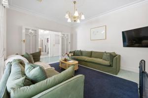 a living room with two couches and a tv at Raygold Park Equestrian Accommodation plus Pool House in Moorooduc