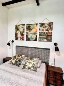 een slaapkamer met een bed met vier foto's aan de muur bij Finca Aisa -Boutique bungalows in Ometepe island in Santa Cruz
