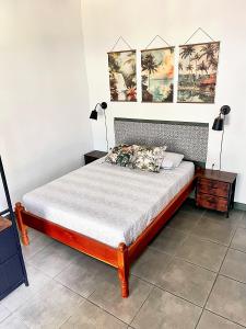 een bed in een slaapkamer met drie foto's aan de muur bij Finca Aisa -Boutique bungalows in Ometepe island in Santa Cruz