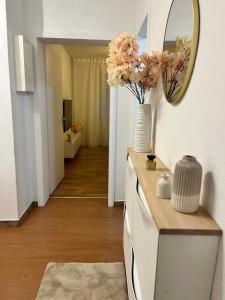 a kitchen with a mirror and a vase with flowers on a counter at Gemütliche, zentrale Wohnung nahe Uni & Düsseldorf in Niederdorla