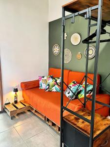 een woonkamer met een oranje bank en een ladder bij Finca Aisa -Boutique bungalows in Ometepe island in Santa Cruz