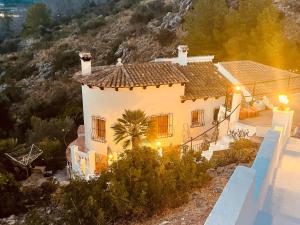 una casa blanca con una palmera delante en Beautiful villa with pool and stunning view, en Boterías