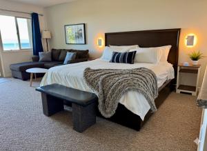 a bedroom with a large bed and a couch at Shorewater Resort Beachfront King Bed Studio in Qualicum Beach