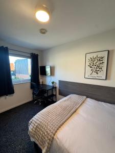 Un dormitorio con una cama y un escritorio y una ventana. en 248 Halls, en Middlesbrough