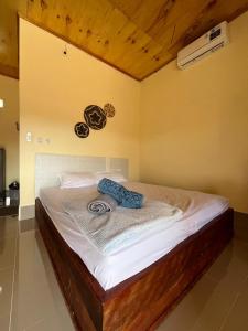 a bedroom with a bed with white sheets and a ceiling at Ekas Elen Homestay in Pulau Gilkaliantan