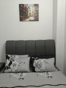 a bed with two pillows and a picture on the wall at Inara Homestay in Kuala Lipis