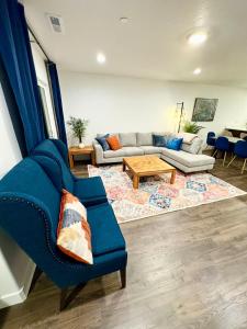 ein Wohnzimmer mit einem blauen Sofa und einem Tisch in der Unterkunft 4BR Townhome near Downtown-SLC Airport in Salt Lake City