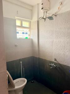 a bathroom with a toilet and a window at Siva Inn in Guruvāyūr