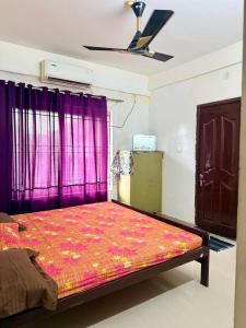 a bedroom with a large bed with purple curtains at Siva Inn in Guruvāyūr