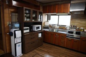 富士市にあるかんさんのお宿の木製キャビネットと冷蔵庫付きの広いキッチンが備わります。