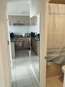 eine Küche mit einer Glastür, die in ein Bad führt in der Unterkunft Condominio cumbres de reñaca ll in Viña del Mar + 7 Fotos