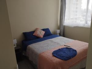 ein kleines Schlafzimmer mit einem Bett und einem Fenster in der Unterkunft Condominio cumbres de reñaca ll in Viña del Mar