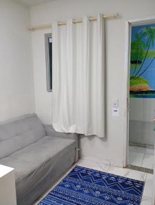 a living room with a couch and a window at Apartamento Completo e Centralizado 2 in Curro Velho