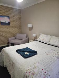 a bedroom with a bed with a robe on it at Murray's Bed & Breakfast in Gnowangerup