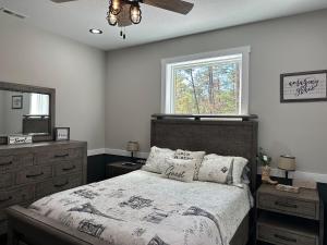 Un dormitorio con una cama y una cómoda y una ventana. en Hidden Gem, en Weaverville