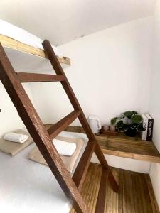a bunk bed with a wooden ladder in a room at San Juan ELYU Beachfront Cabin in San Juan