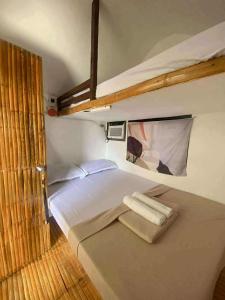 a bedroom with a bed with two towels on it at San Juan ELYU Beachfront Cabin in San Juan
