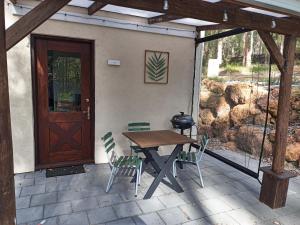 a wooden table and chairs on a patio with a door at Kent River Retreat in Kentdale