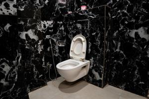 baño con aseo blanco en una pared negra en The Sweven Rishikesh, en Rishīkesh 80 fotos más