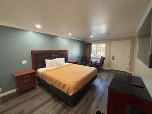 a hotel room with a bed and a desk and a room at Economy Inn - Burbank Airport in Sun Valley