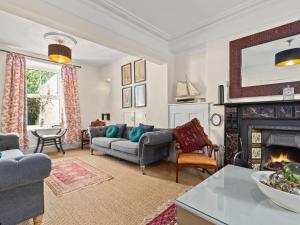 a living room with a couch and a fireplace at Tremle in Penbryn